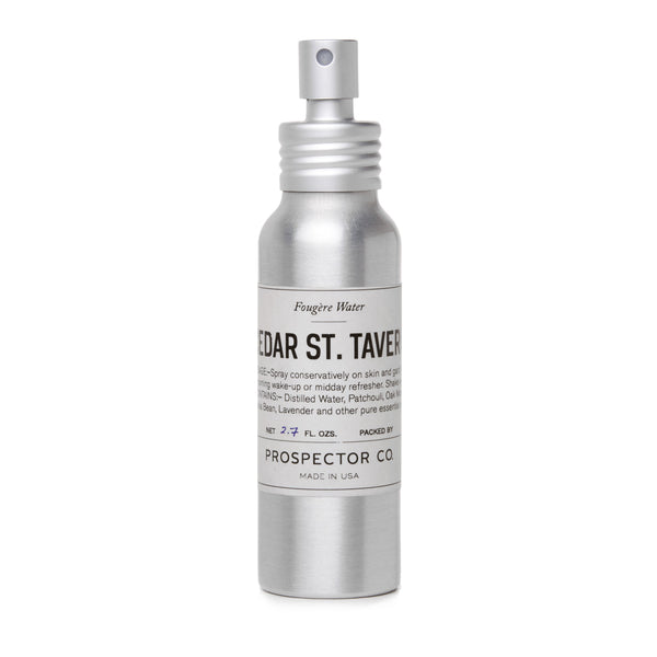 A metal spray bottle of product with silver cap and cream-colored ingredients label.