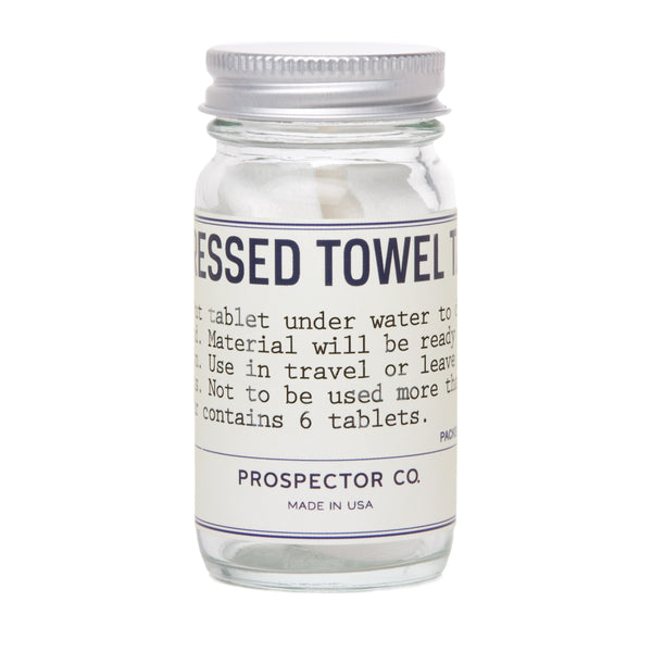 A clear glass cylinder bottle of white-colored tablets with silver cap and cream-colored ingredients label.