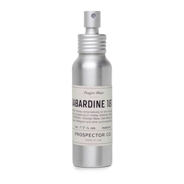 A metal spray bottle of product with silver cap and cream-colored ingredients label.